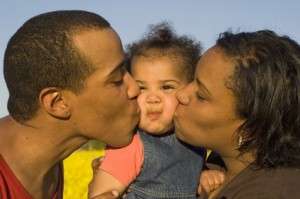 Parents kissing their cute little baby