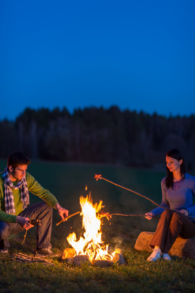 Couple cook by bonfire romantic night countryside
