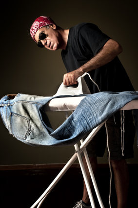 Man ironing a pair of jeans