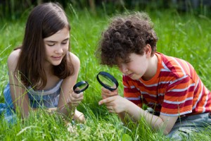 Kids looking through magnifying glass