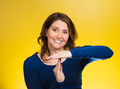 Closeup portrait, young, happy, smiling woman showing time out gesture with hands, isolated yellow background. Positive human emotions, facial expressions, feelings, body language, reaction, attitude